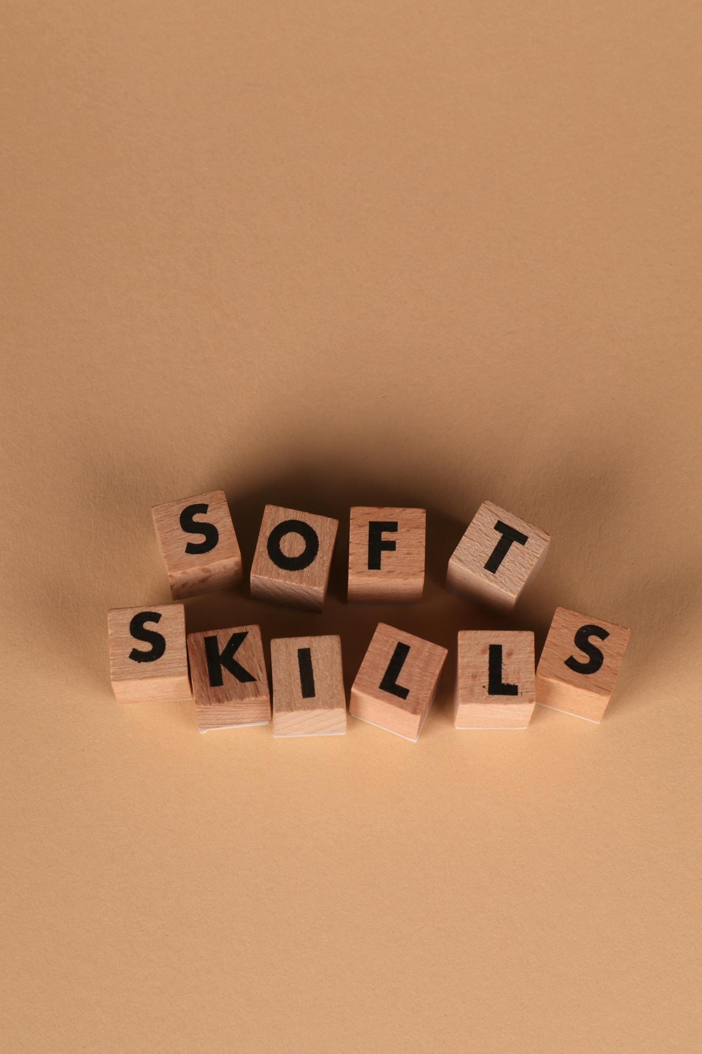 Wooden blocks arranged to spell 'Soft Skills' on a brown background